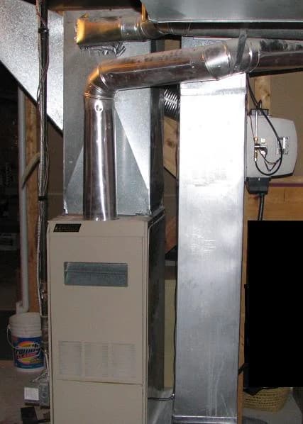 An installed Lennox forced-air gas furnace beside its sheet-metal ductwork.