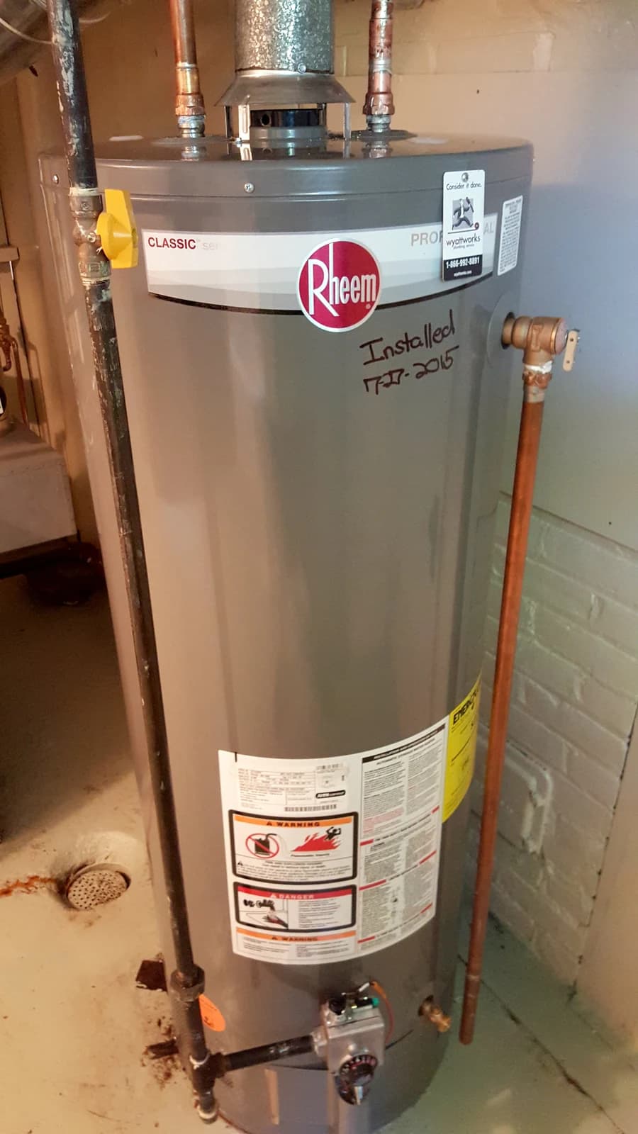 A real Rheem gas storage water heater with copper water lines, draft hood and gas control.
